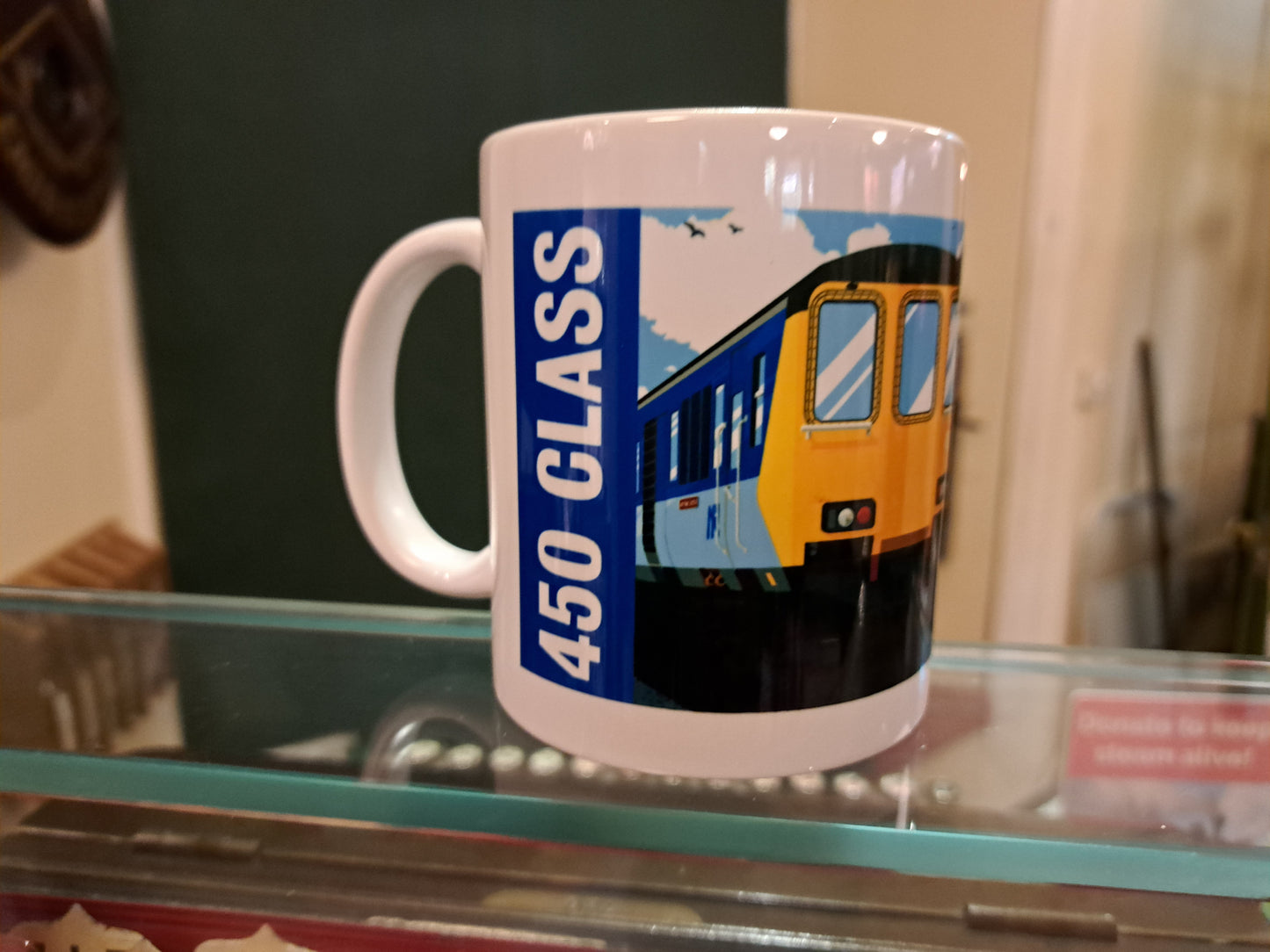 Mug with a train design and '450 Class' text on a glass surface.